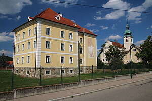 Sitzendorf an der Schmida, Hauptplatz Nr. 1: ehem. Schloss, heute Neue Mittelschule, ab 1765 errichtet, im Hintergrund die Pfarrkirche